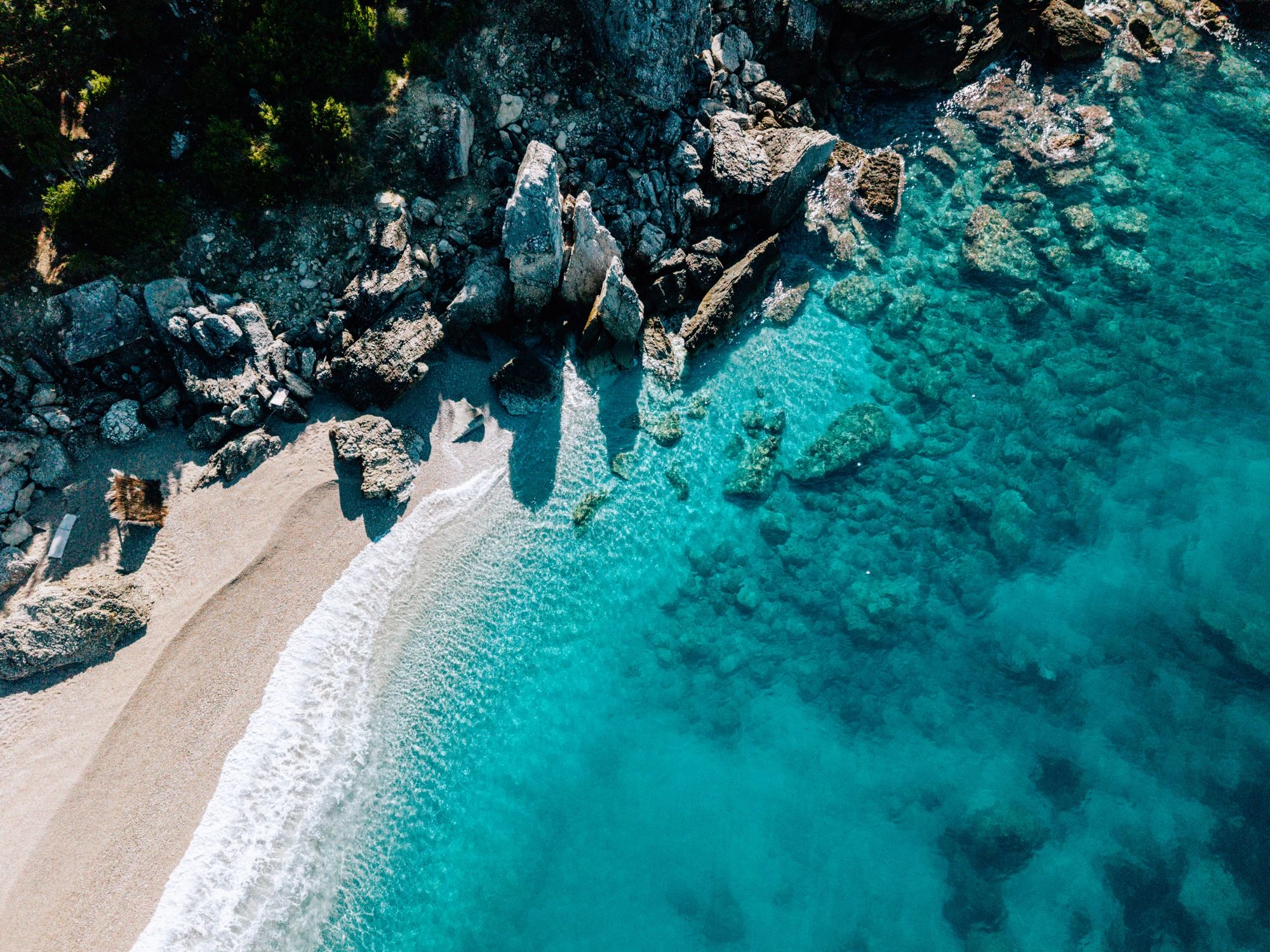 Aerial view of a rocky shoreline and turquoise water